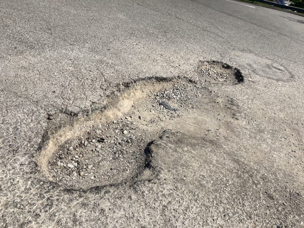 Pothole repair needed in a parking lot managed by a property management company in Nashville