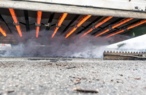 Image of underneath an infrared asphalt repair machine. The asphalt repair company is performing infrared asphalt repair for a trench in Murfreesboro, TN