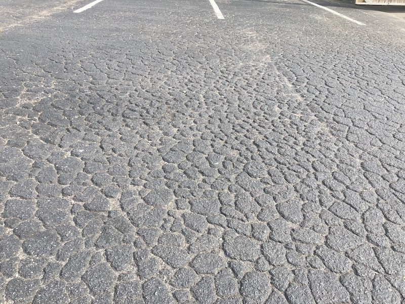 Image of asphalt cracking, also known as alligator cracking and fatigue cracking. This picture is from a parking lot in need of asphalt patching in West Nashville